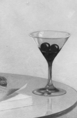 On her table, a martini glass with olives awaits her.