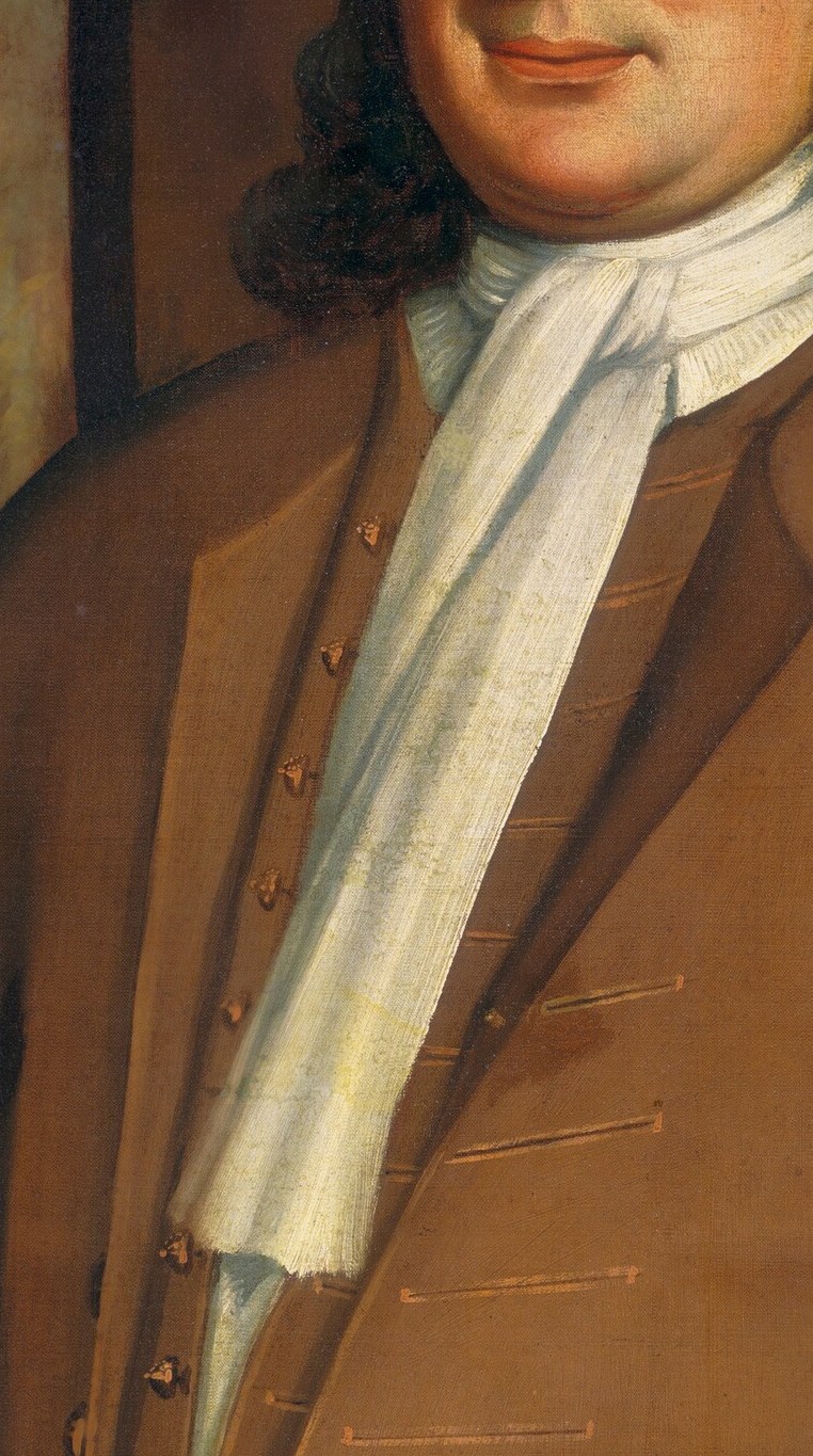 The folds of his crisp white scarf highlight his status.