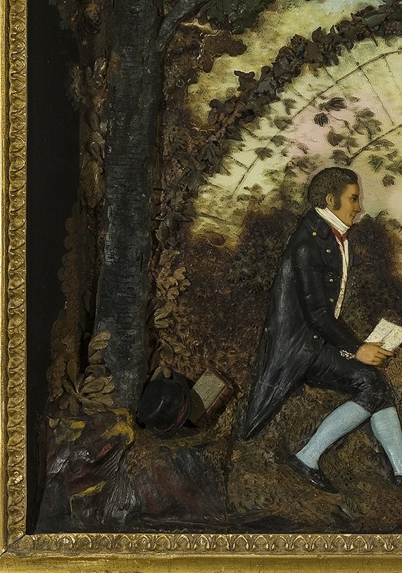 Father kneels with a book, teaching his child.