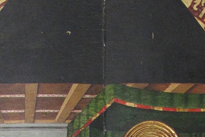 Look into the gap between the canopy and the green curtain.