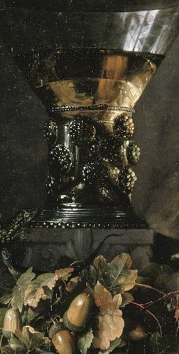 The ornate wine glass holds golden liquid.