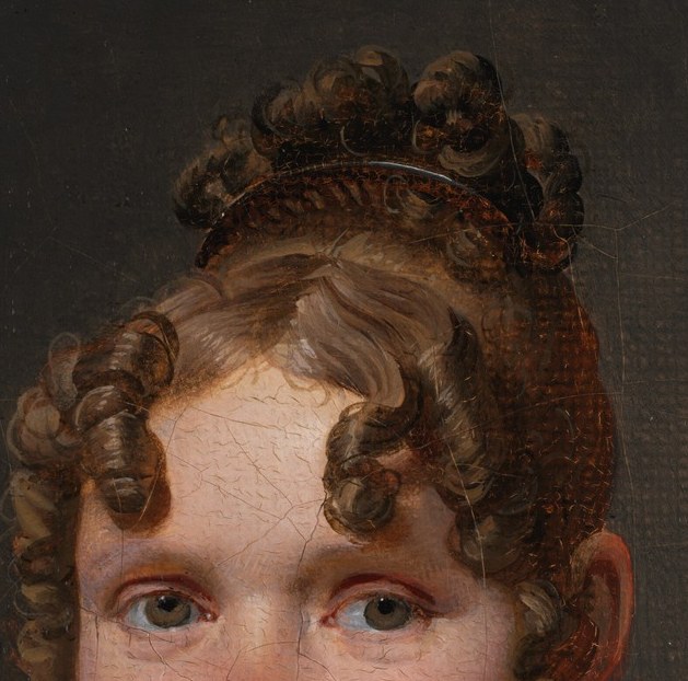 Her elaborate hairstyle shows the fashion of her time.
