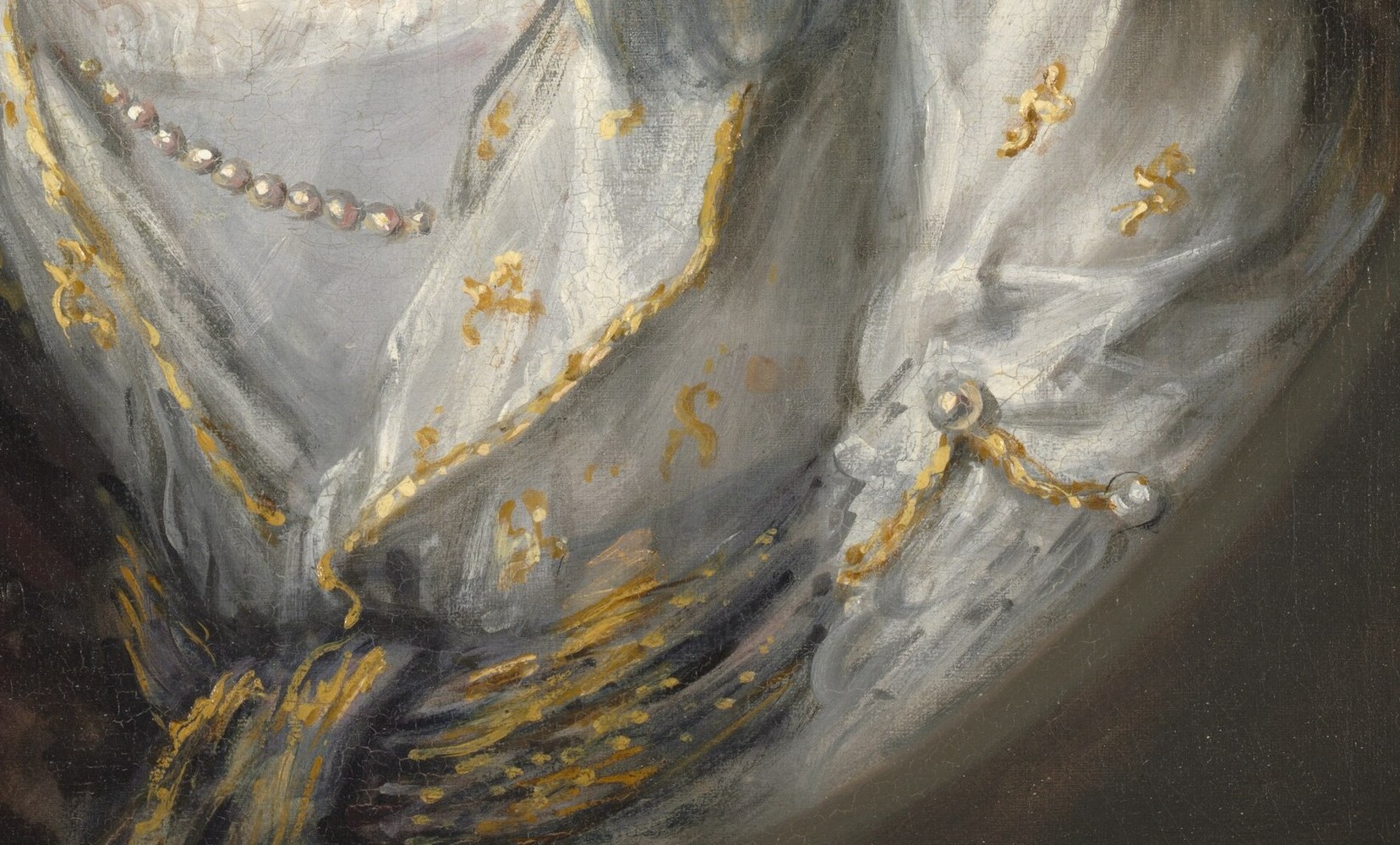 The gold embroidery gleams on her dress.