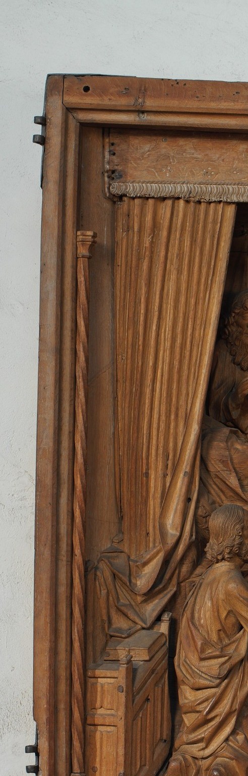 Theatrical curtain parted like a stage reveal frames the scene and signals sacred interior space , a common device in Flemish-influenced carving of this period