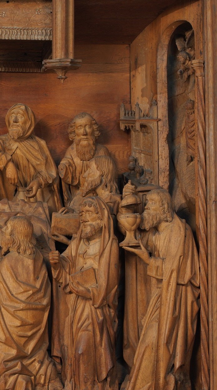 Three or four figures in varied robes form a tight group expressing collective mourning; their staggered depth demonstrates the relief carver's spatial skill