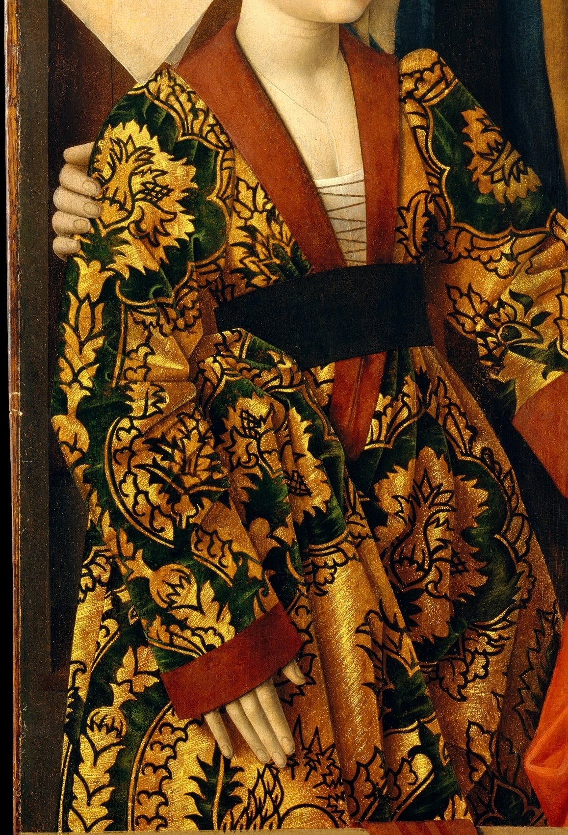 The textile pattern is painted with extraordinary specificity , the woven interlace and color can be matched to actual Flemish silk production; it is both a status marker and a technical tour de force of oil paint.