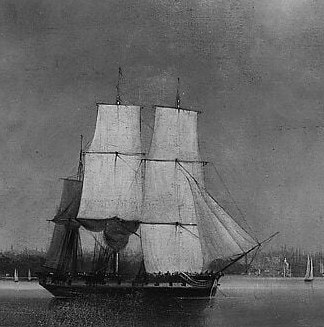 Its sails are full, suggesting movement and the power of wind in a busy harbor.