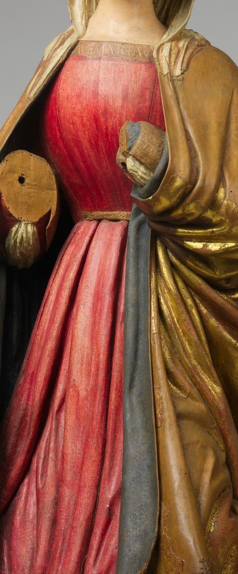 She kneels in prayer, adorned in a vibrant robe.