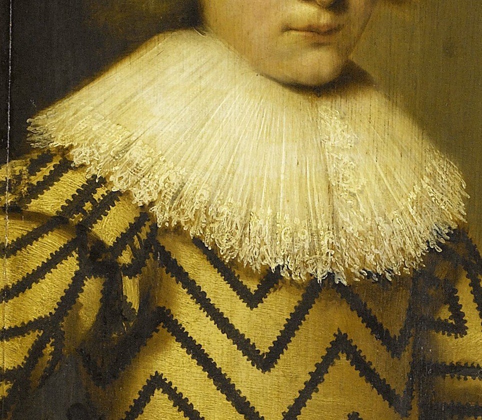 The crisp white fabric contrasts sharply with his costume, highlighting the detail and texture of the ruff.