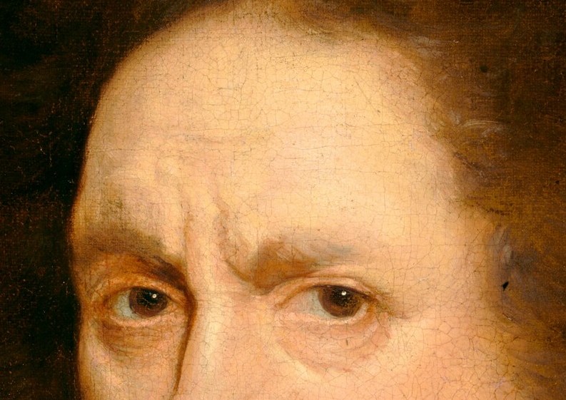 His face is serious, almost severe, with a tightly set mouth.
