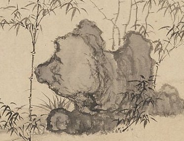 The rock formations provide a grounding contrast to the bamboo.