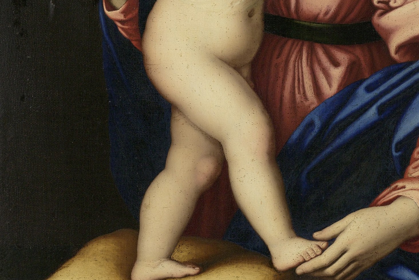 The cushion elevates the Child literally and symbolically; the warm gold anchors the lower palette and the implied throne-like setting identifies this as a devotional rather than narrative scene.