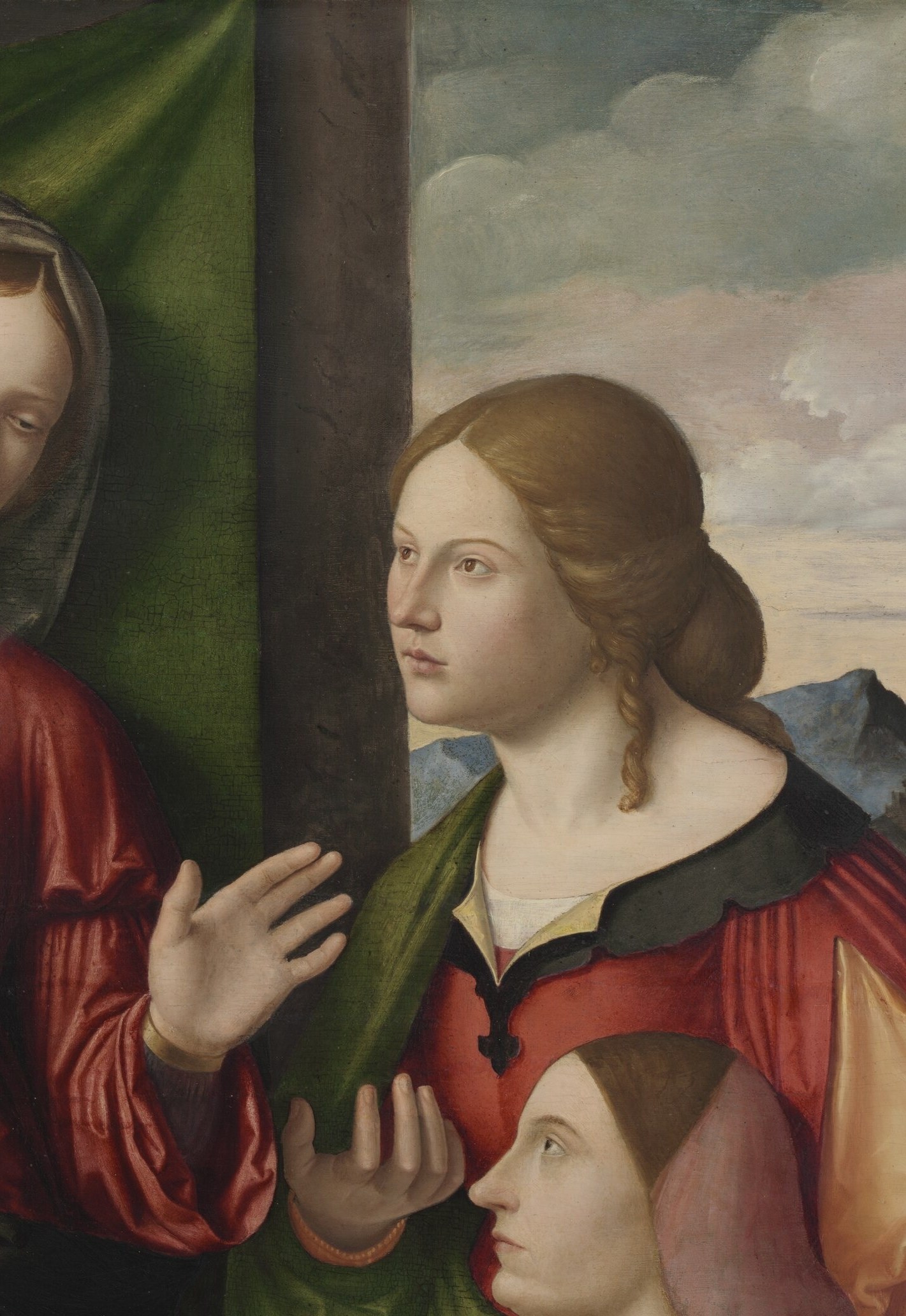 Her vivid red-over-green palette and sidelong gesture toward the Virgin mark her as the female donor's intercessor , possibly Catherine or Mary Magdalene.