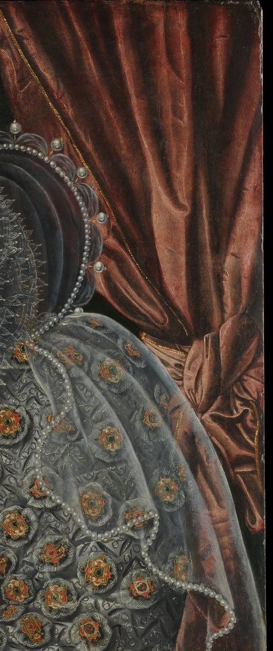 The saturated red sets off the silver-grey of the gown through complementary contrast , a deliberate studio prop that also signals interior wealth and theatrical gravitas.