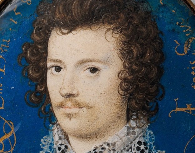 The voluminous, dark, curly hair frames his face and is a hallmark of Elizabethan fashion.
