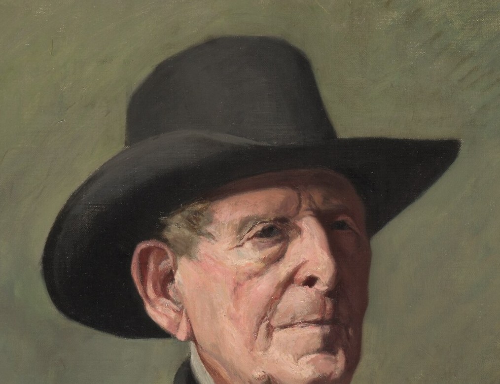 The hat casts a shadow, adding to the dramatic lighting and framing his face.