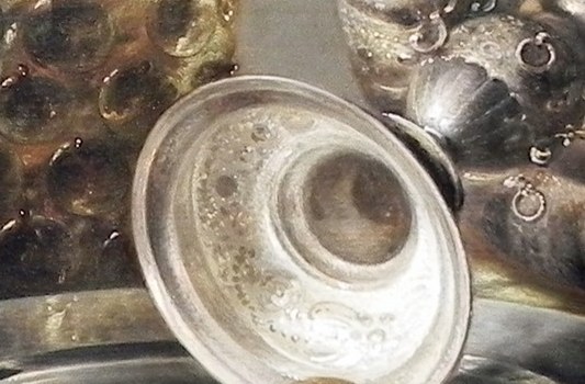 Look closely at the inverted silver cup, resting on a pearl.