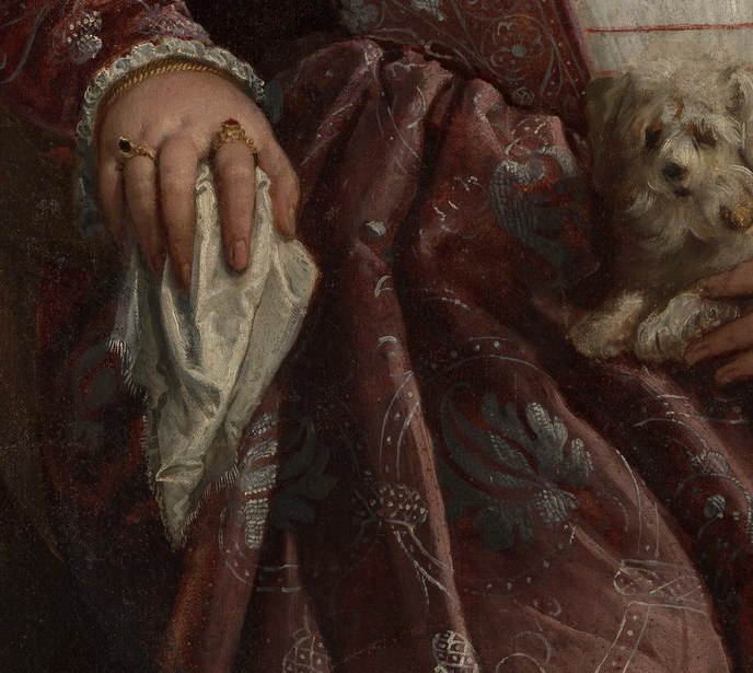She holds one glove still off, the pause before a formal entrance.