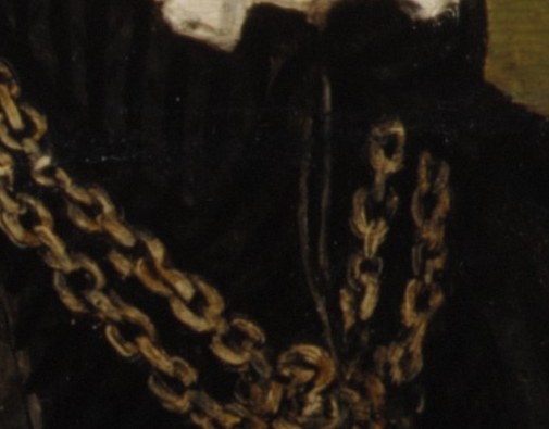 He wears a heavy gold chain, a mark of status.