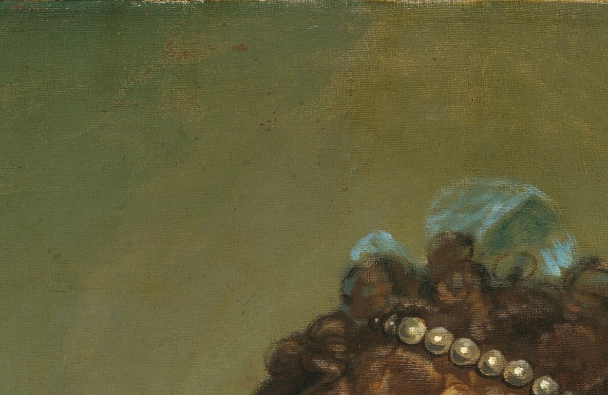 The pearl band across her forehead declares social rank.