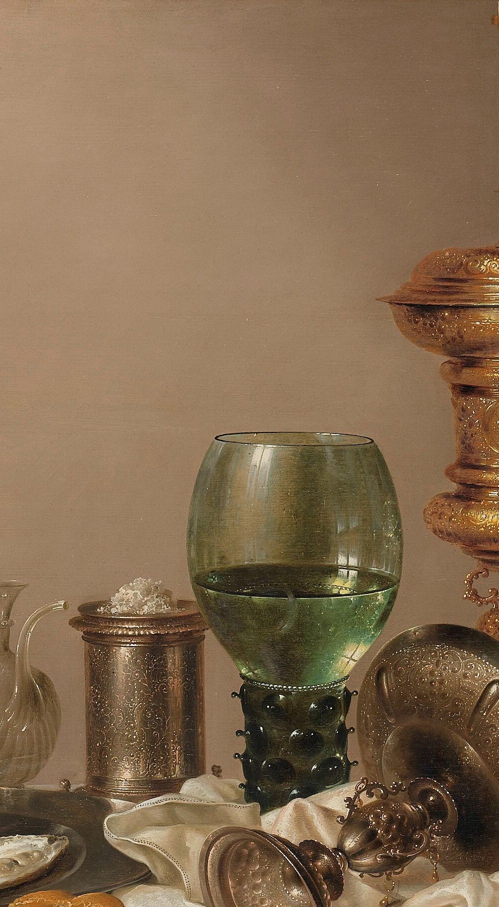 The centerpiece named in the title; the amber-gold chased stem and domed lid signal wealth and status , its vertical height commands the entire composition.