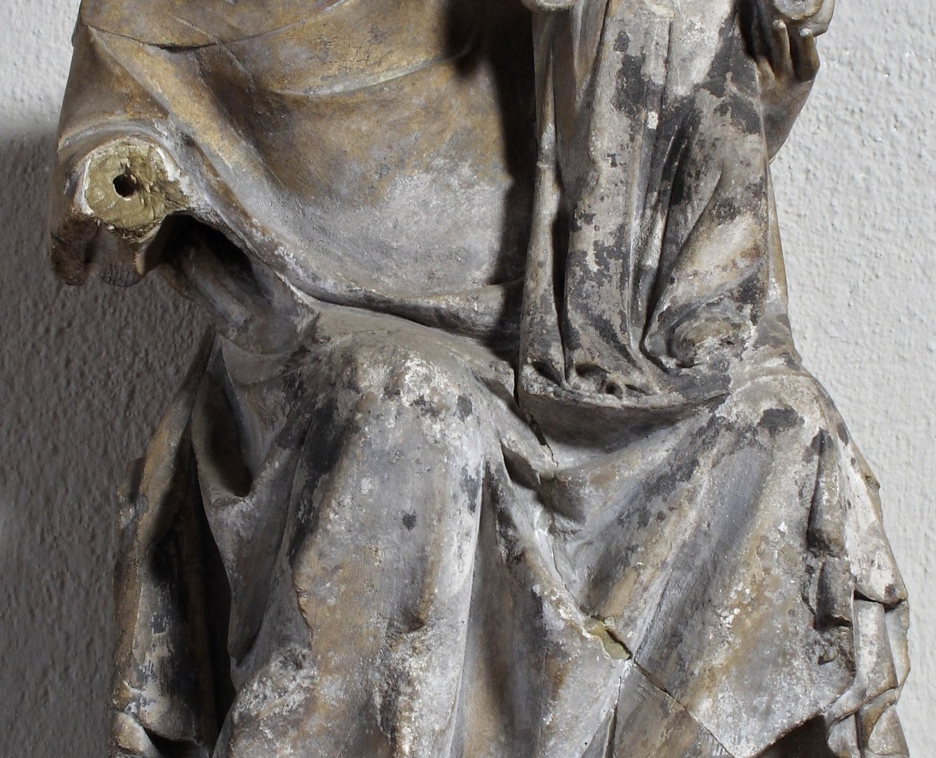 The solid, grounded form of the mother's torso provides a stable base for the child, symbolizing strength and support.