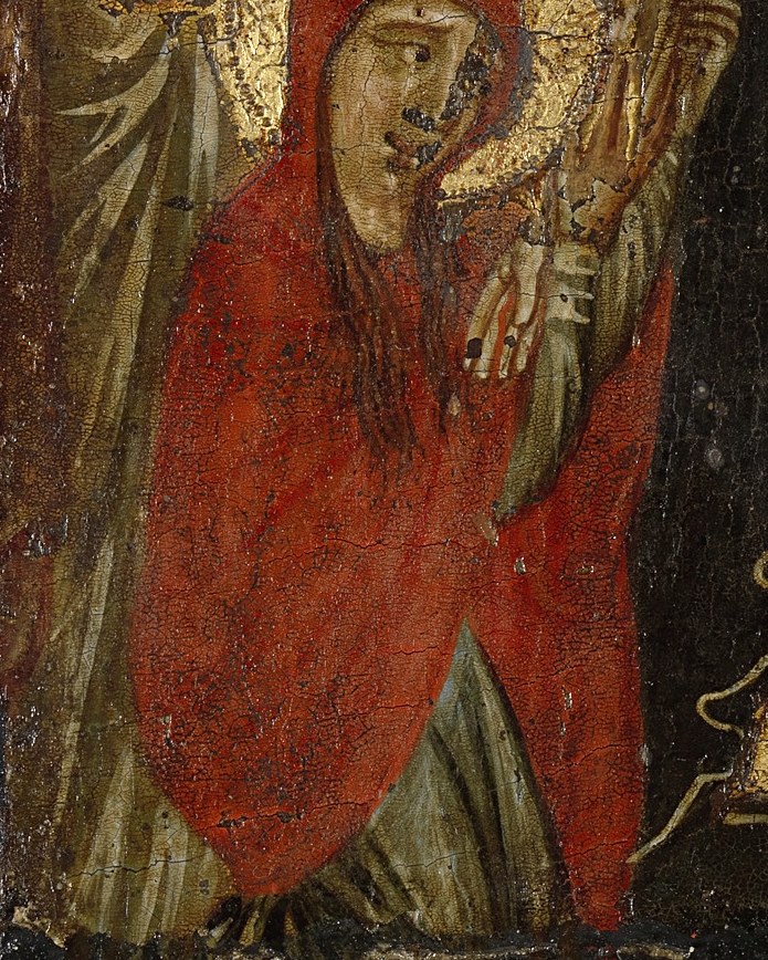 Mary kneels in red. Her head is bowed.