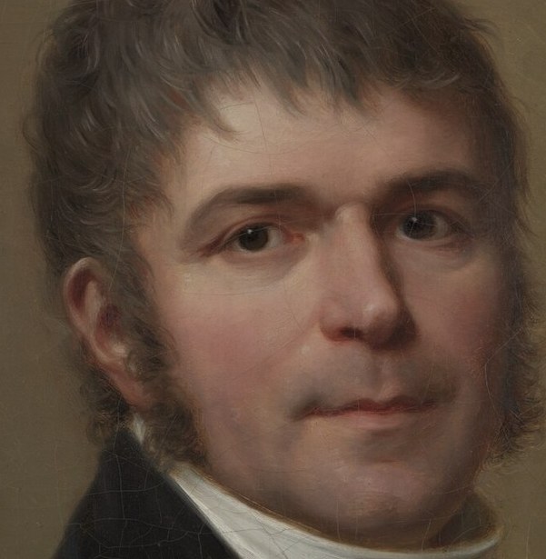 Chiaroscuro sculpts his face.