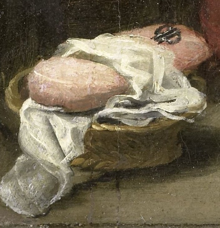 A small basket contains swaddling clothes, quietly awaiting.