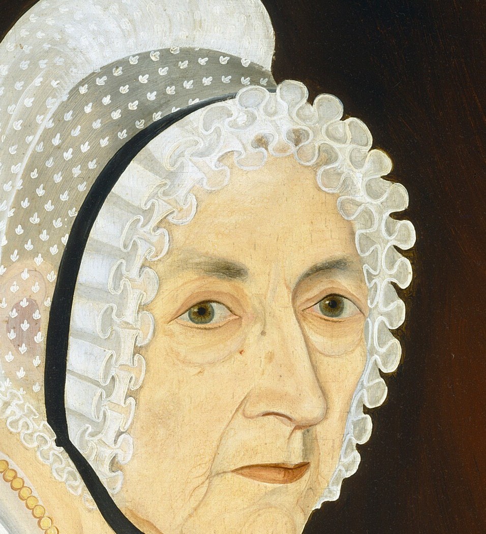 Her expression is subtle, conveying a lifetime of experience and quiet contemplation.