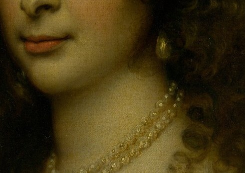 Her lustrous pearl necklace signals purity and wealth.