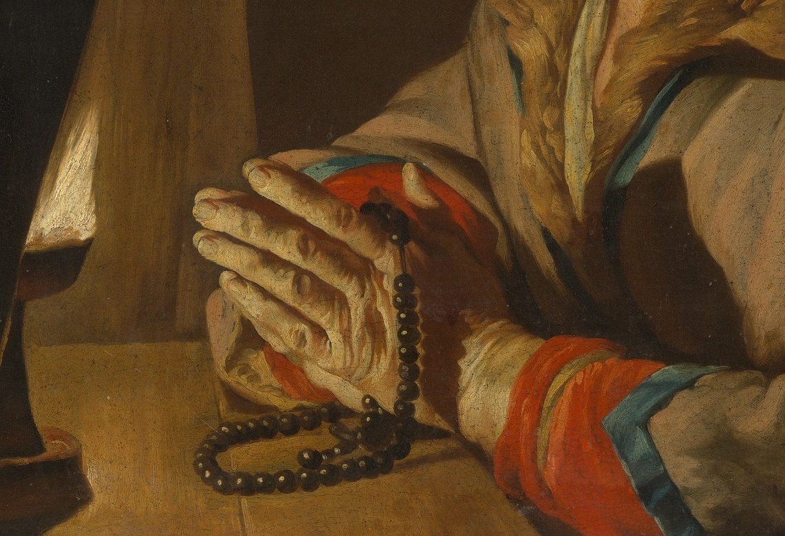 Her clasped hands protect it from the dark.