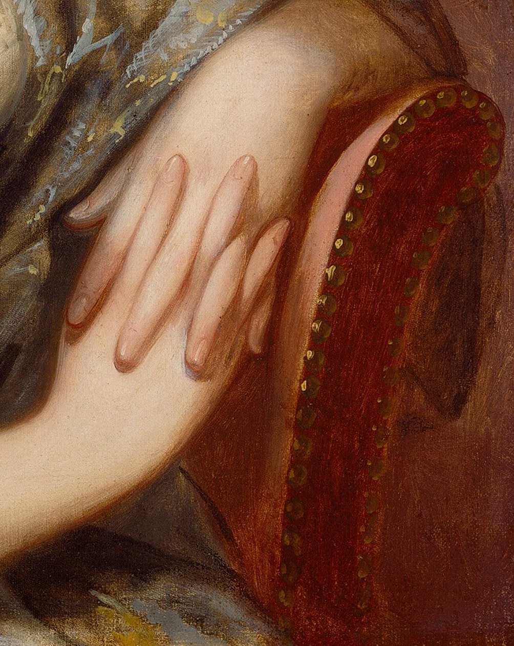 The rich red of the armchair provides a strong contrast to her white gown and adds a sense of opulence.