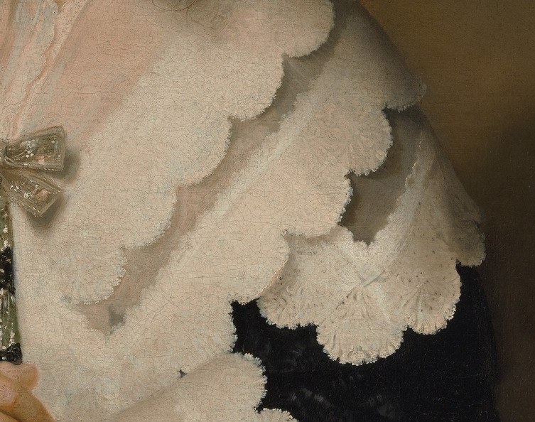 Her quiet elegance shows in her ruffled collar and pearls.