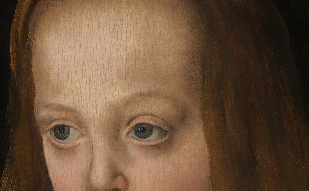 She looks straight out, unblinking.