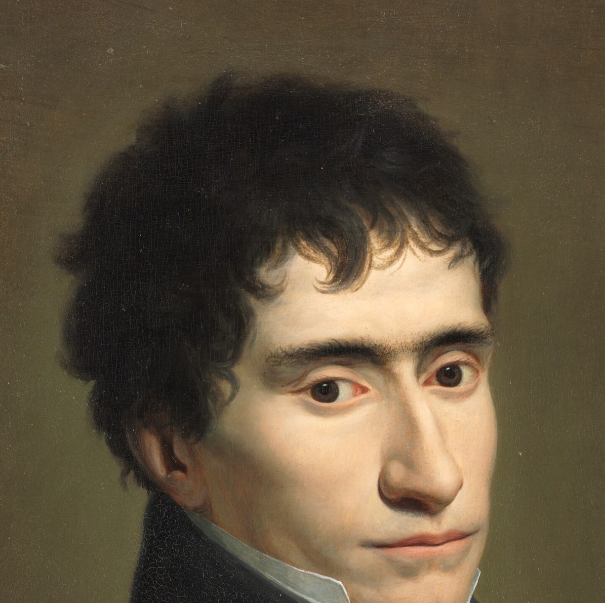 His direct gaze and slightly parted lips suggest a moment of contemplation or performance.