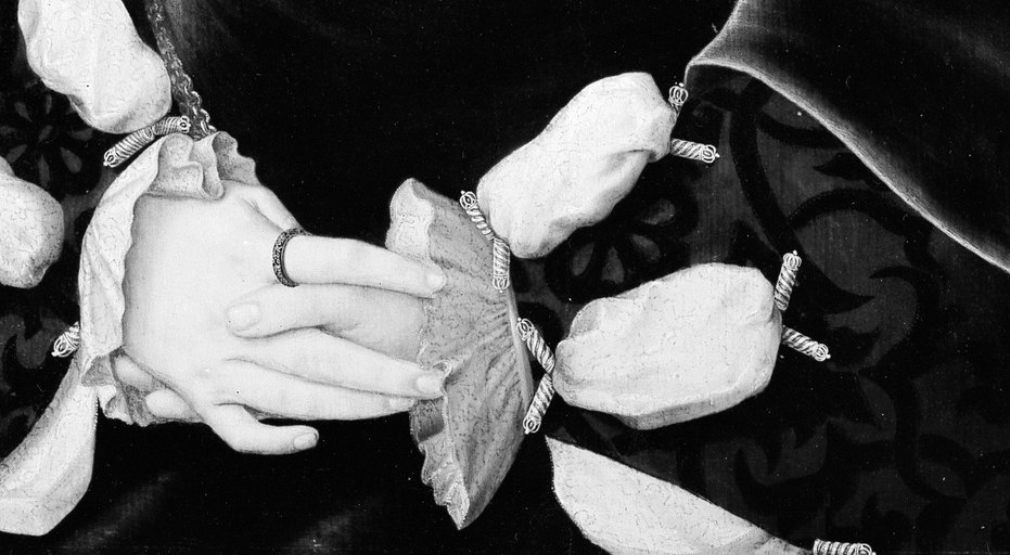 Her hands hold a locket and floral fabric.