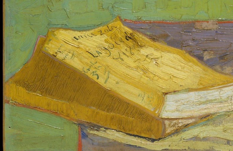 An open yellow book sits beside the flower vase.