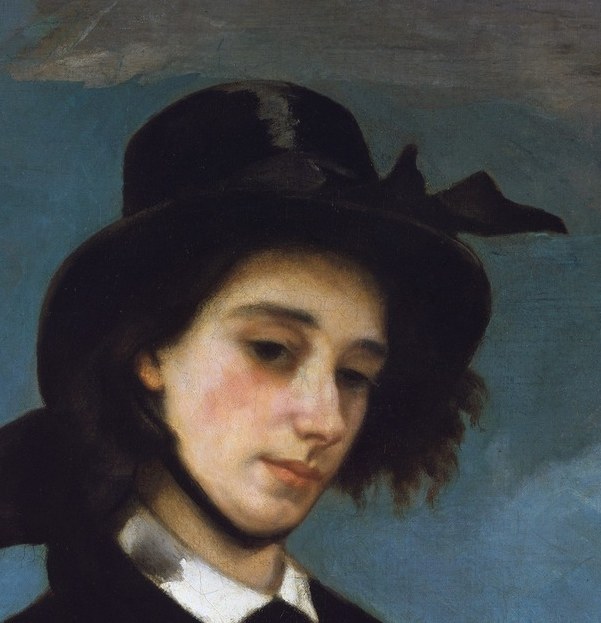 The wide brim and dark color create a dramatic silhouette, framing her face and adding an air of mystery.