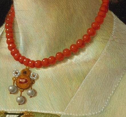 Look just below the coral. A devotional pendant guards her chest.